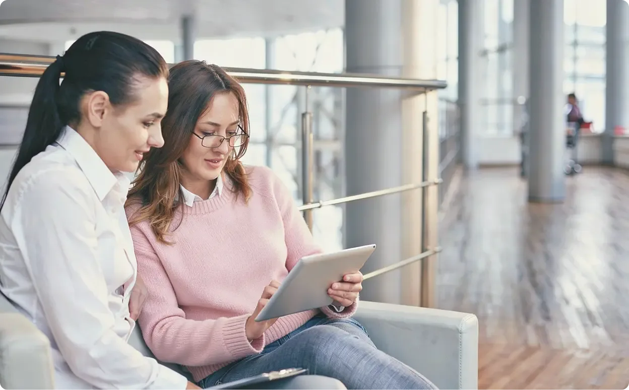 Two healthcare practitioners looking at health data on a tablet.