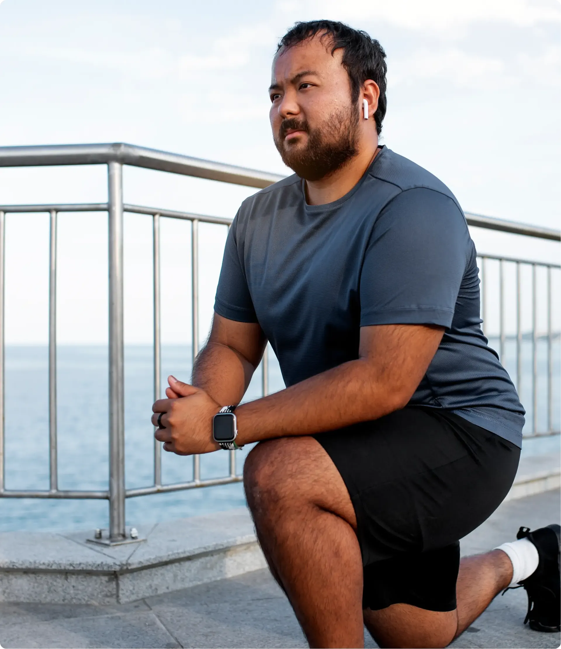 Male doing exercises on a waterfront boardwalk.