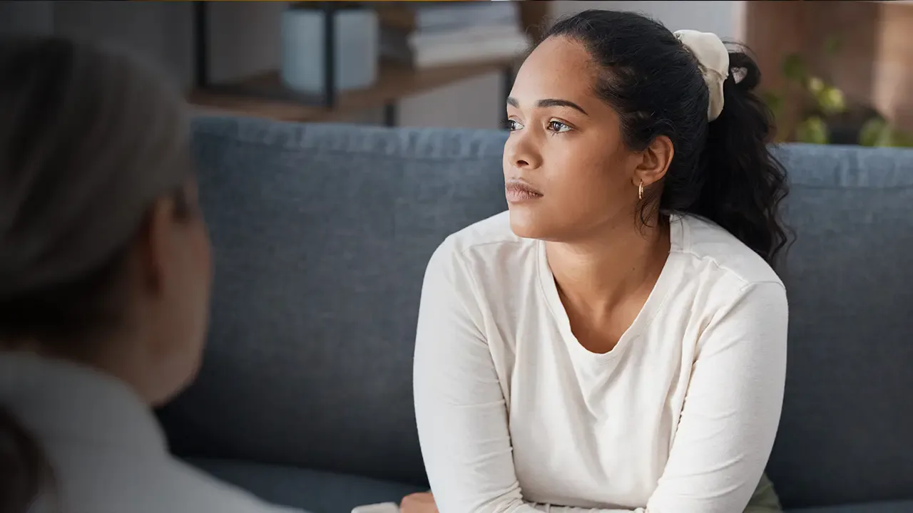 Female counselor with patient sitting on couch.