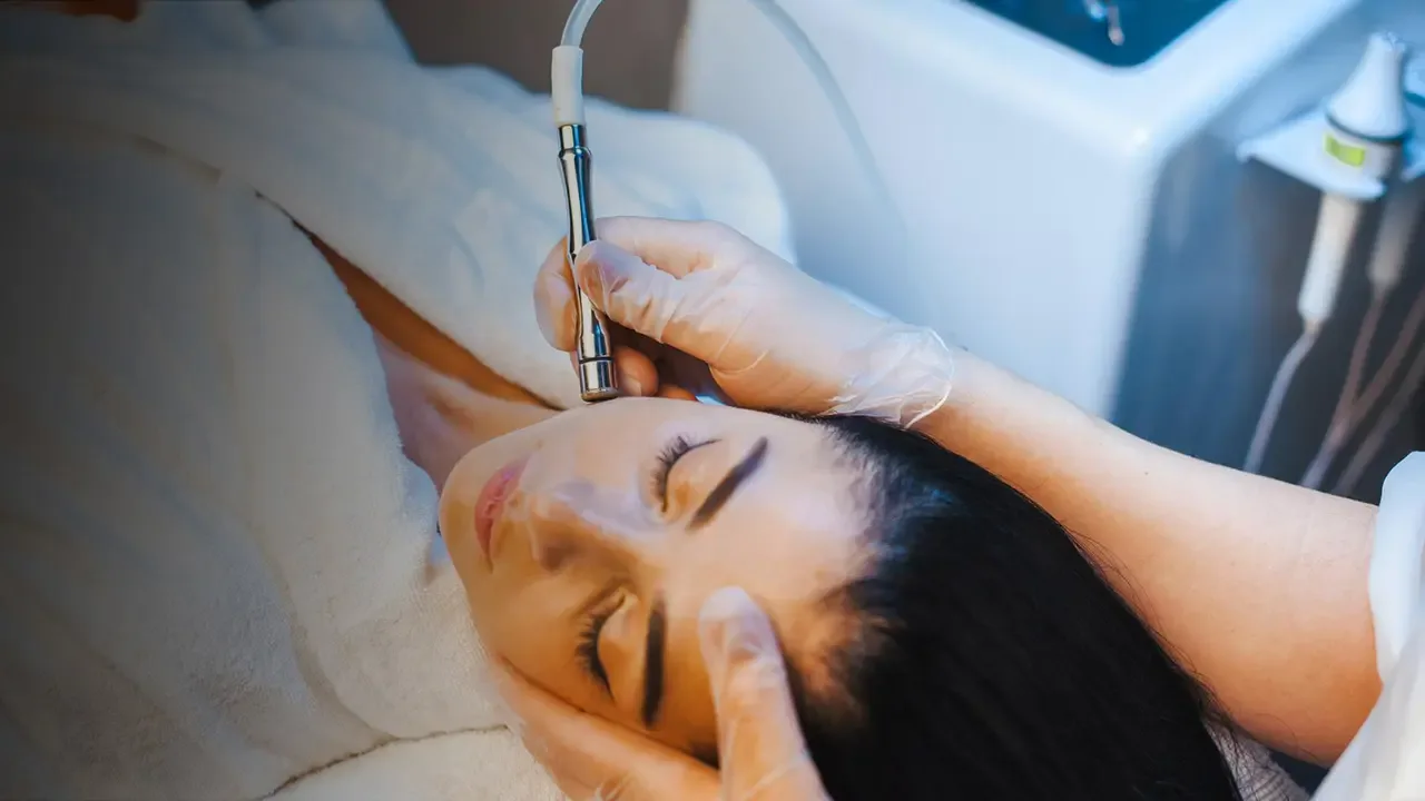 Woman receiving a facial treatment with a microdermabrasion device.