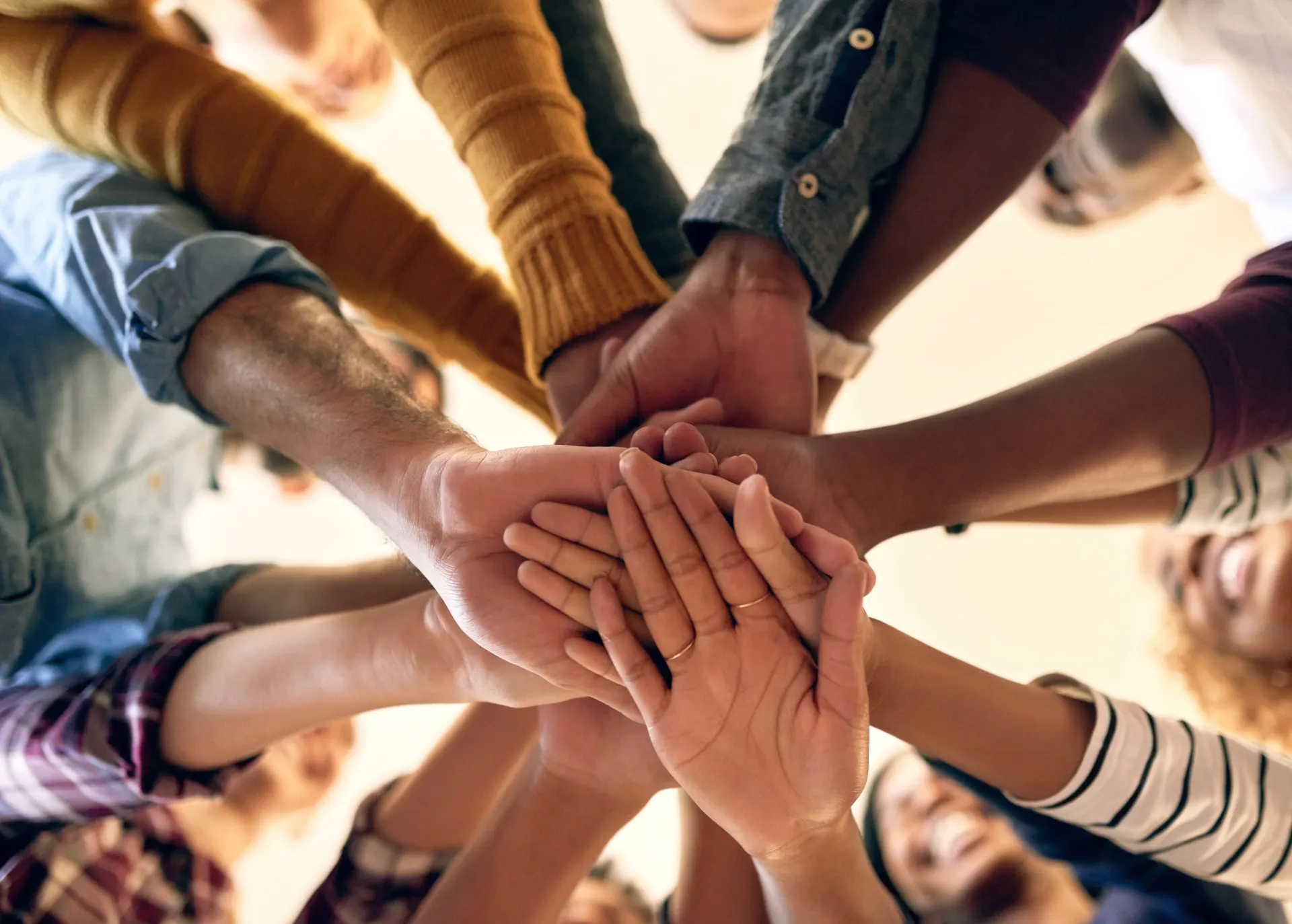 A group of people stacking their hands together in a circle.